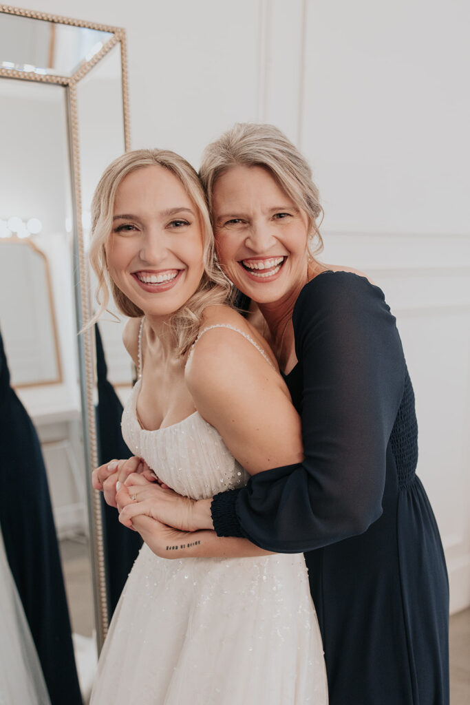 bride and her mother smiling together before ceremony
