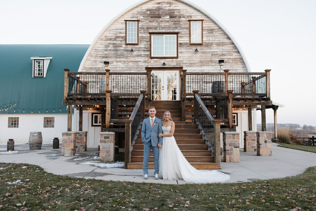 bride and groom standing in front of Stone Hill Barn