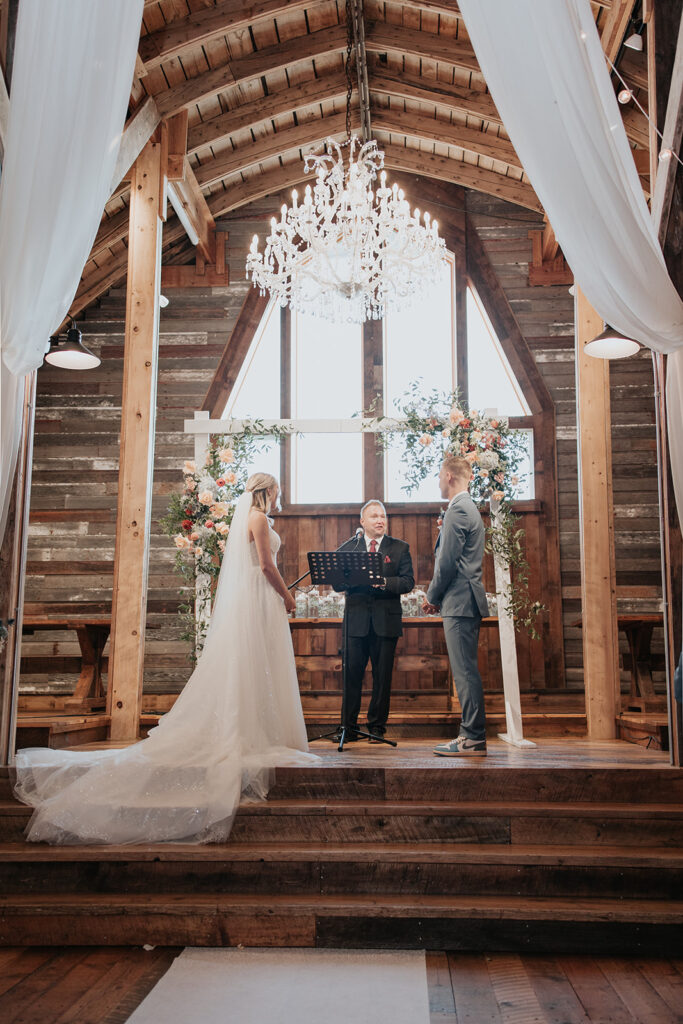 bride and groom standing on the podium for their Stone Hill Barn wedding