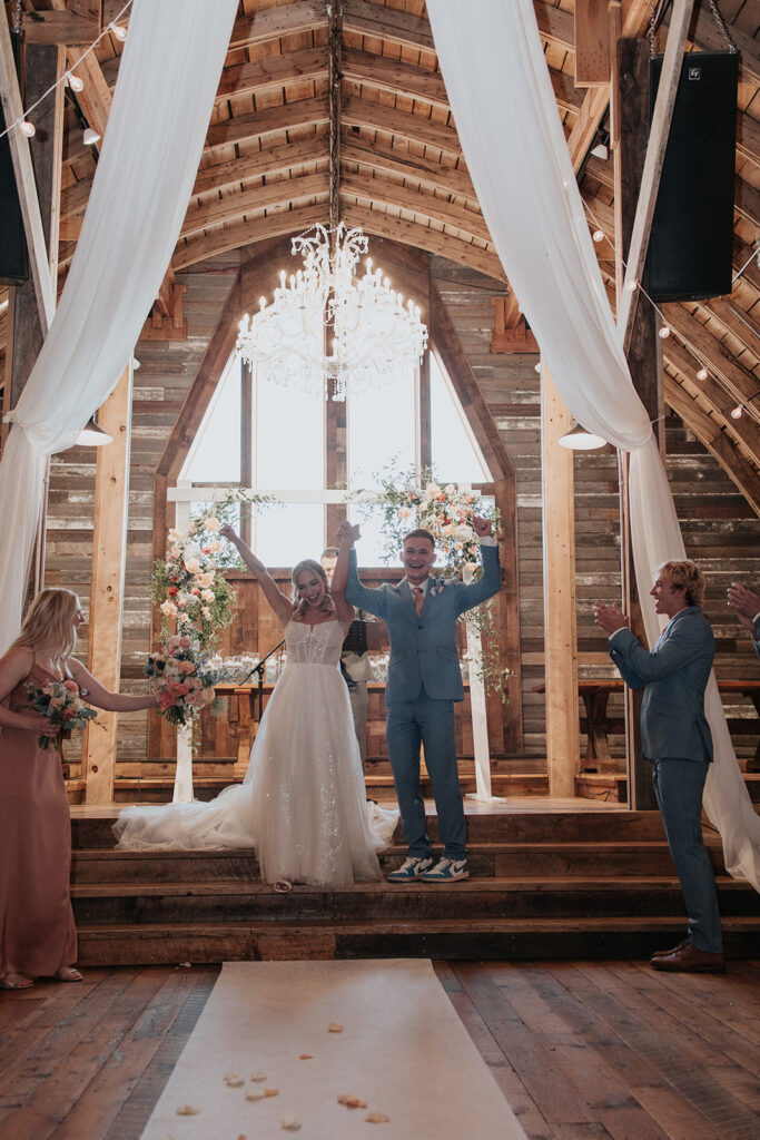 bride and groom standing on the podium for their Stone Hill Barn wedding