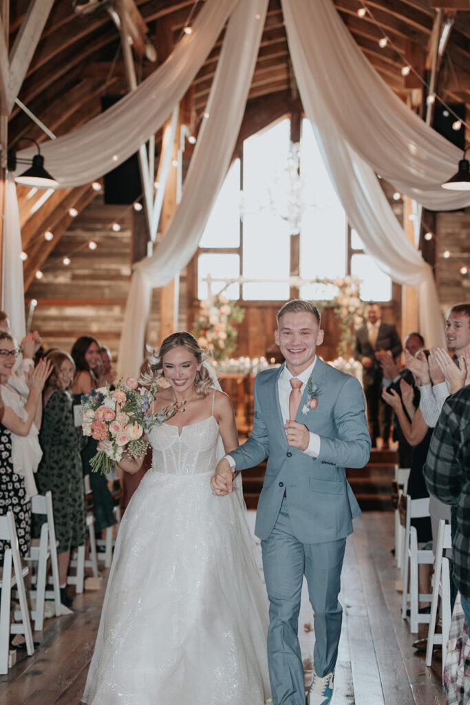 bride and groom walk down the aisle together as a married couple