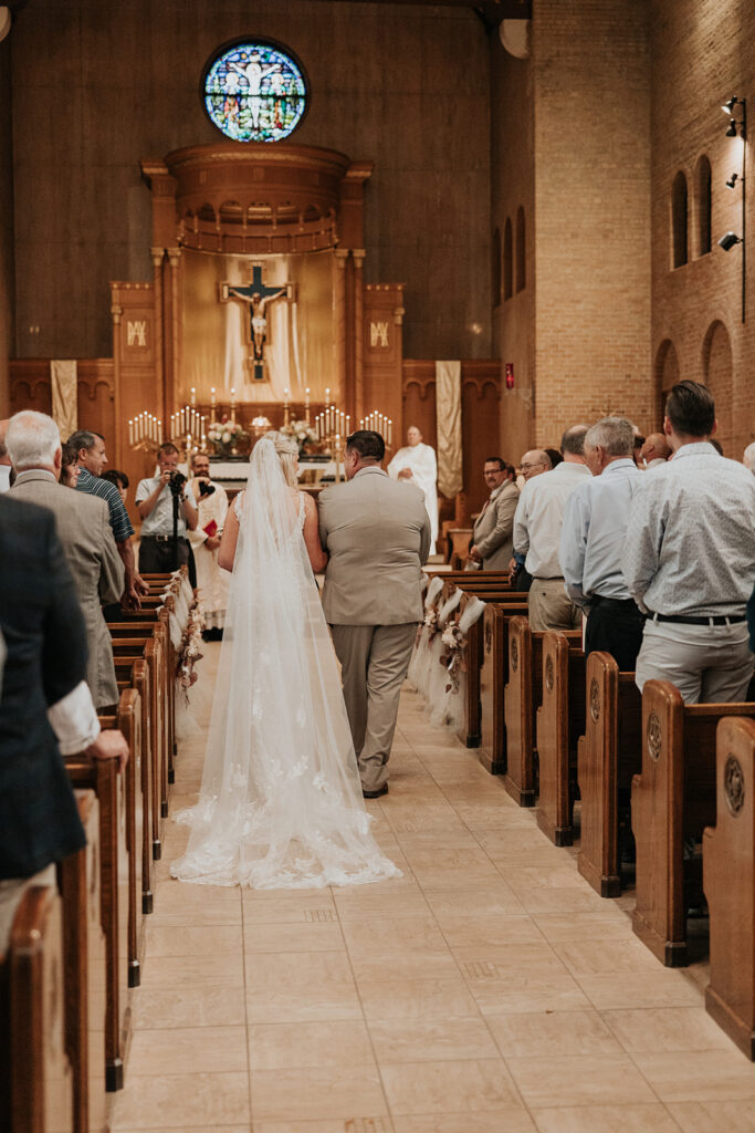 bride and father walk down the aisle together