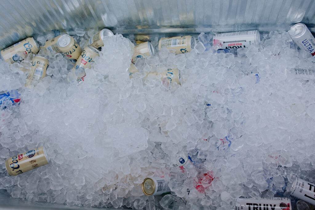 beer cans sitting on ice in a trough