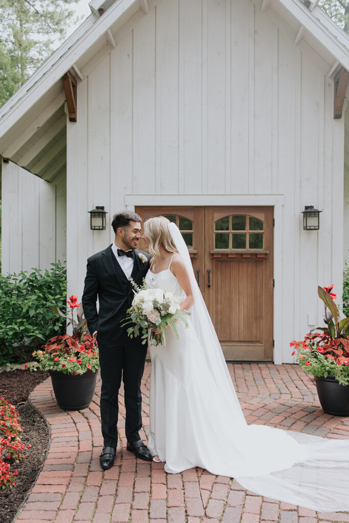 Bride and groom standing in front of the Grand View Lodge chapel