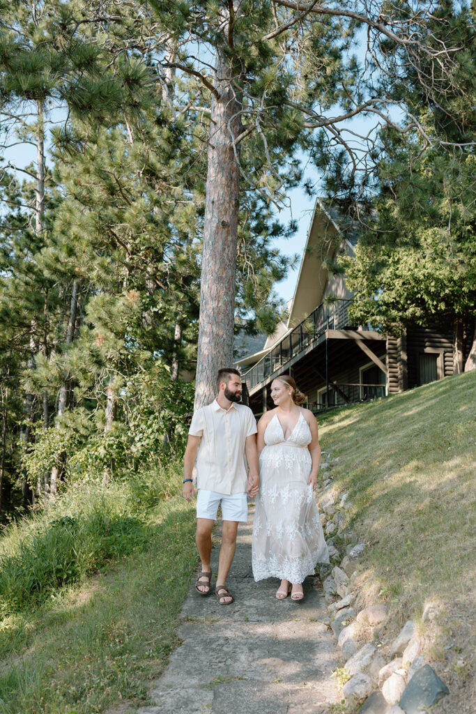 Bride and groom walking down a trail from Madden's resort on Gull Lake