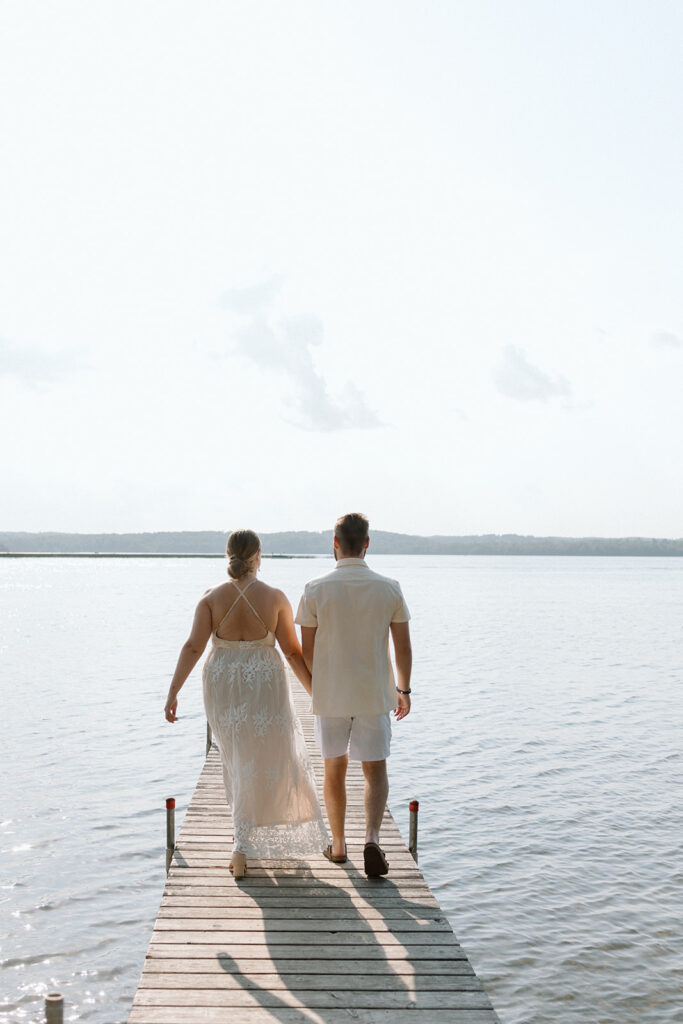 bride and groom walking on a dock from Madden's on Gull Lake