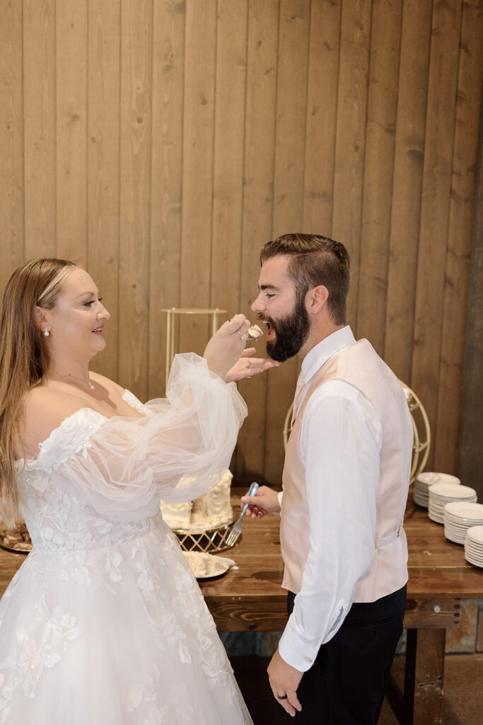 bride feeding groom a bite of cake