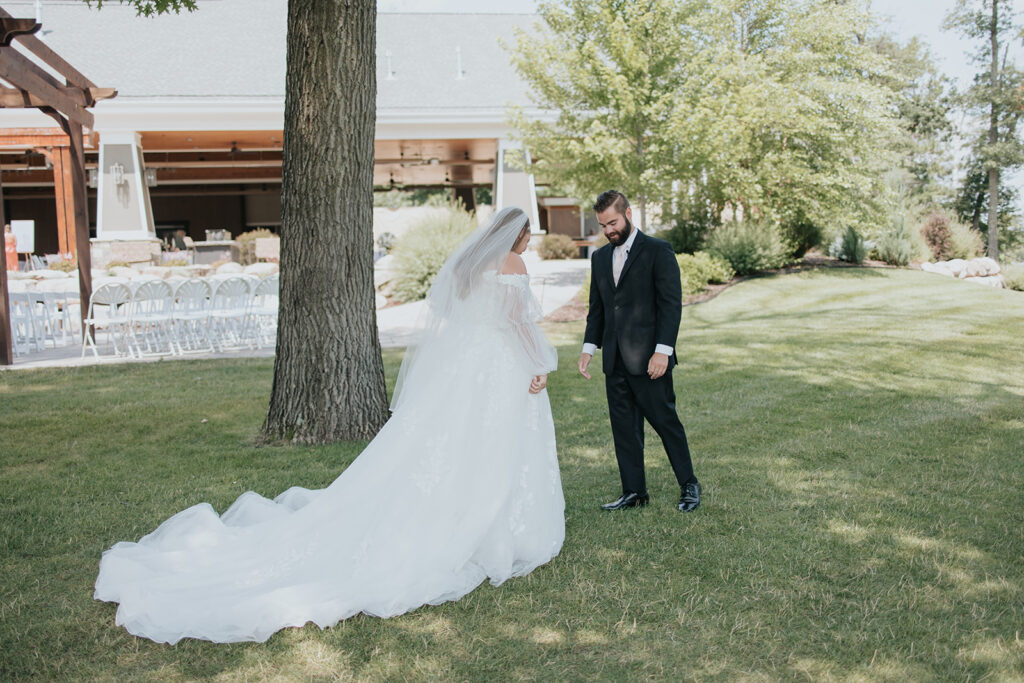 Bride and groom first look on the lawn at Madden's on Gull Lake