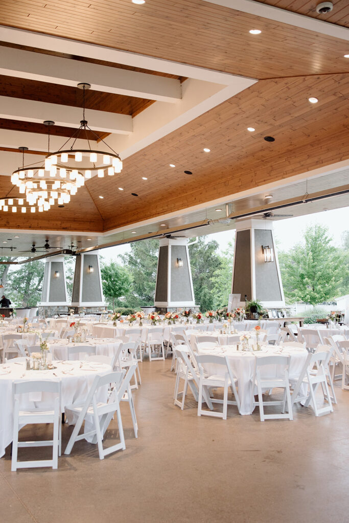 Clean and simple wedding reception table settings under the pavillion.