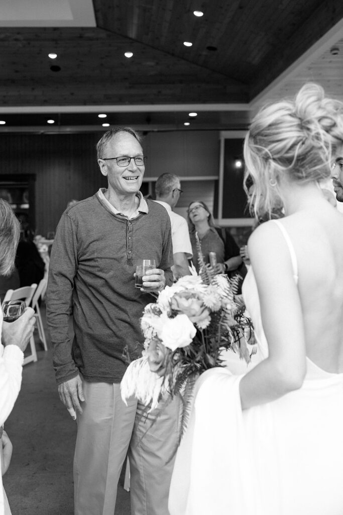 Bride says hello to her father as she walks into the reception