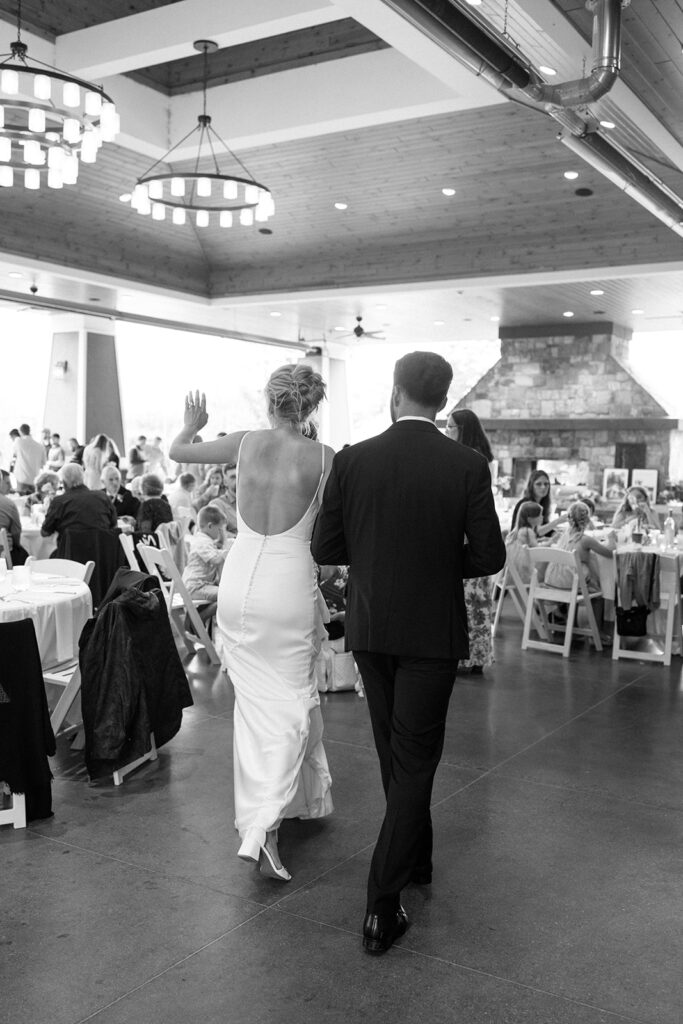 Bride and groom walk into the pavillion together for their wedding reception