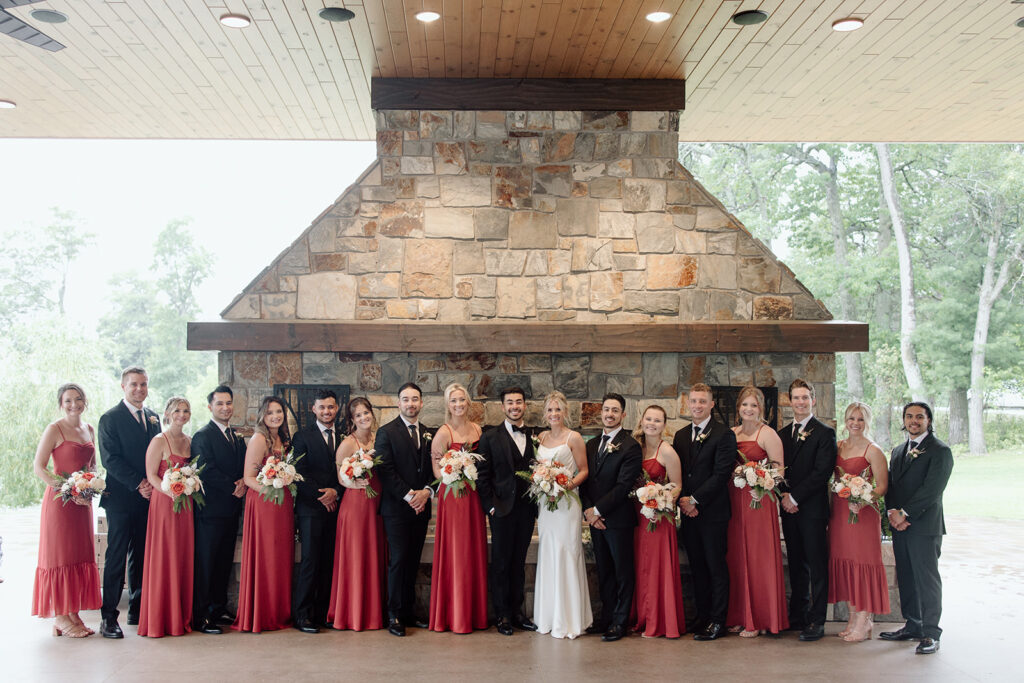 Bride and groom stand lined up in a girl-boy pattern with their wedding party