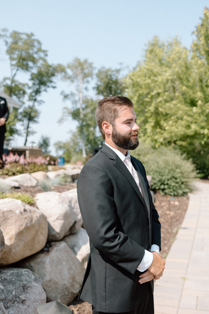 Groom watching his bride walk down the aisle