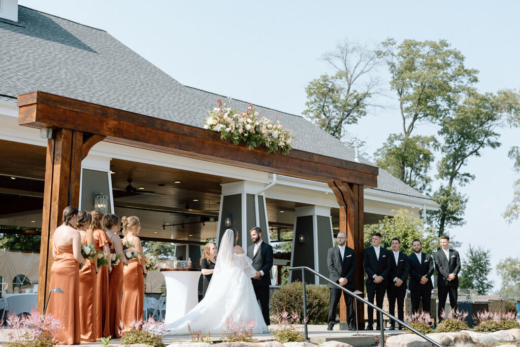 Bride and groom standing at the altar with their wedding party at Madden's on Gull Lake