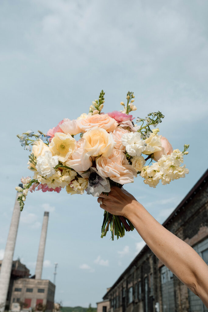 Bridesmaids in colorful dresses holding vibrant bouquets by Bloom Designs
