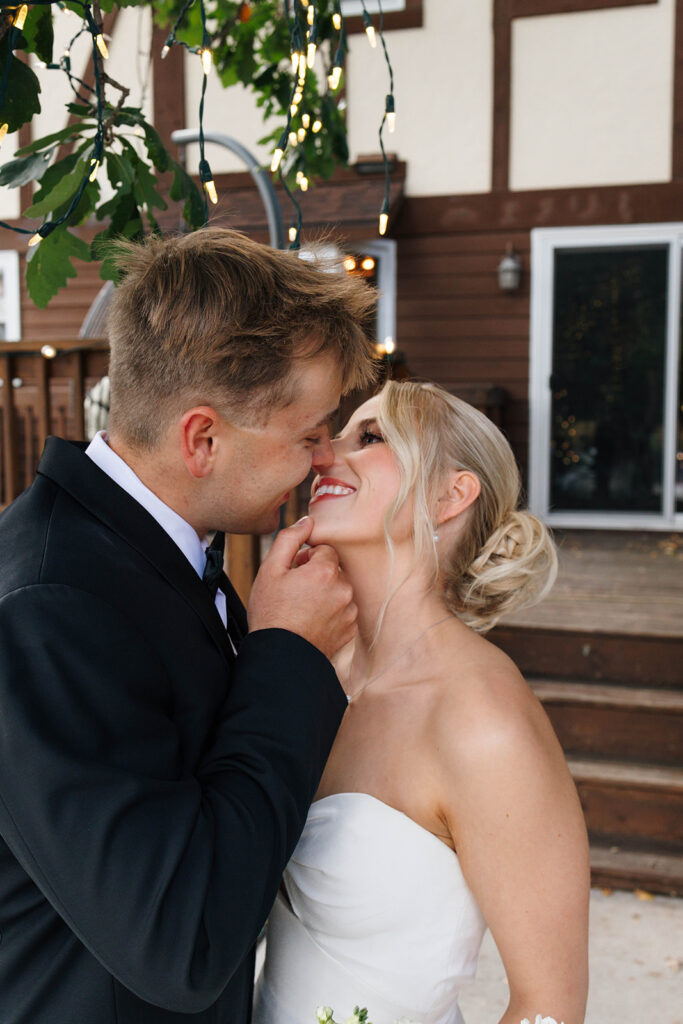 Bride and groom dancing under string lights at their reception
