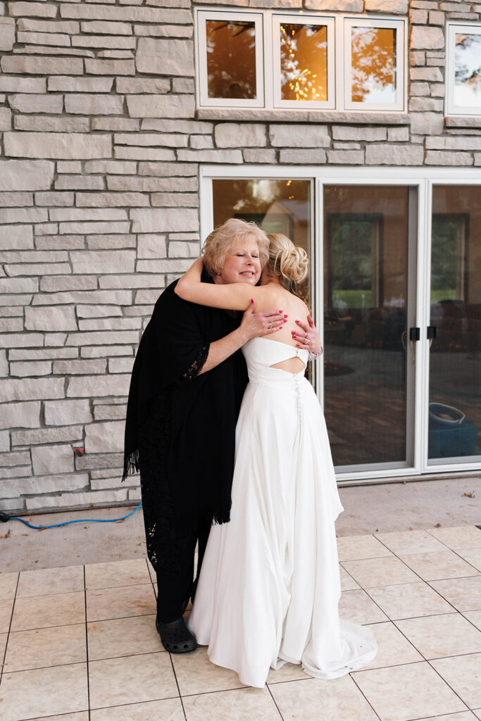 Guests enjoying the outdoor reception under the large tree with hanging lights
