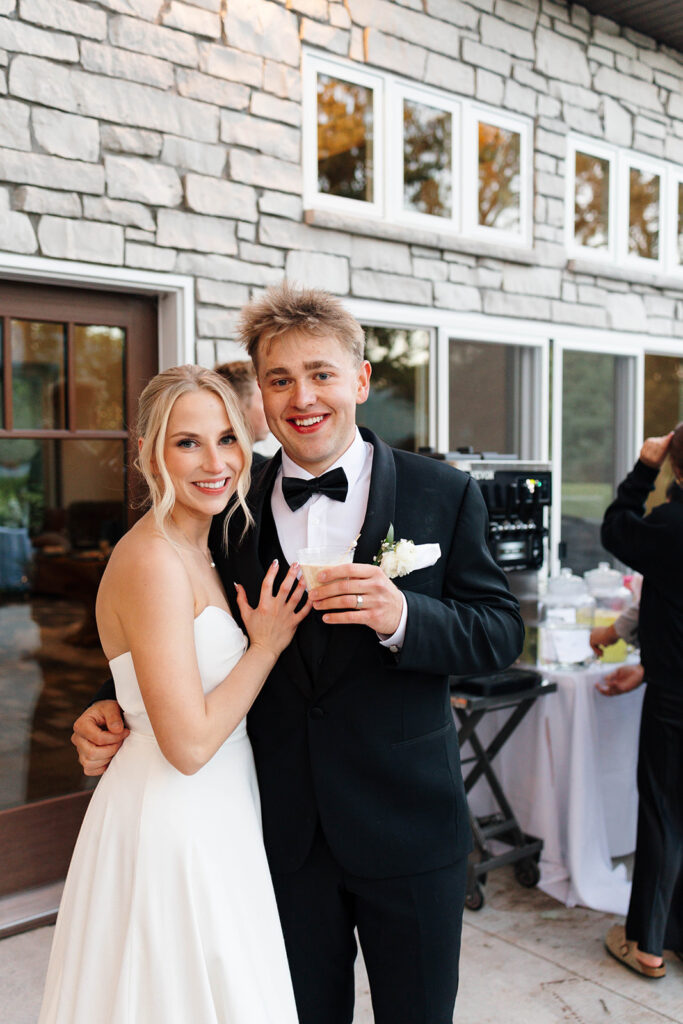 Bride and groom dancing under string lights at their reception
