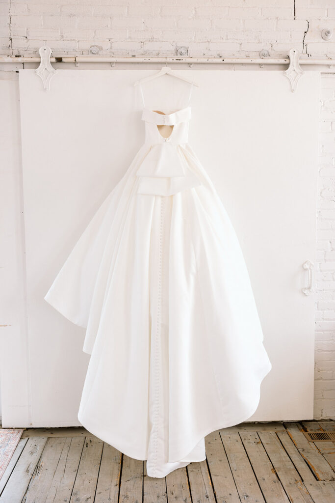 Bride posing in her wedding gown with natural light streaming through the window
