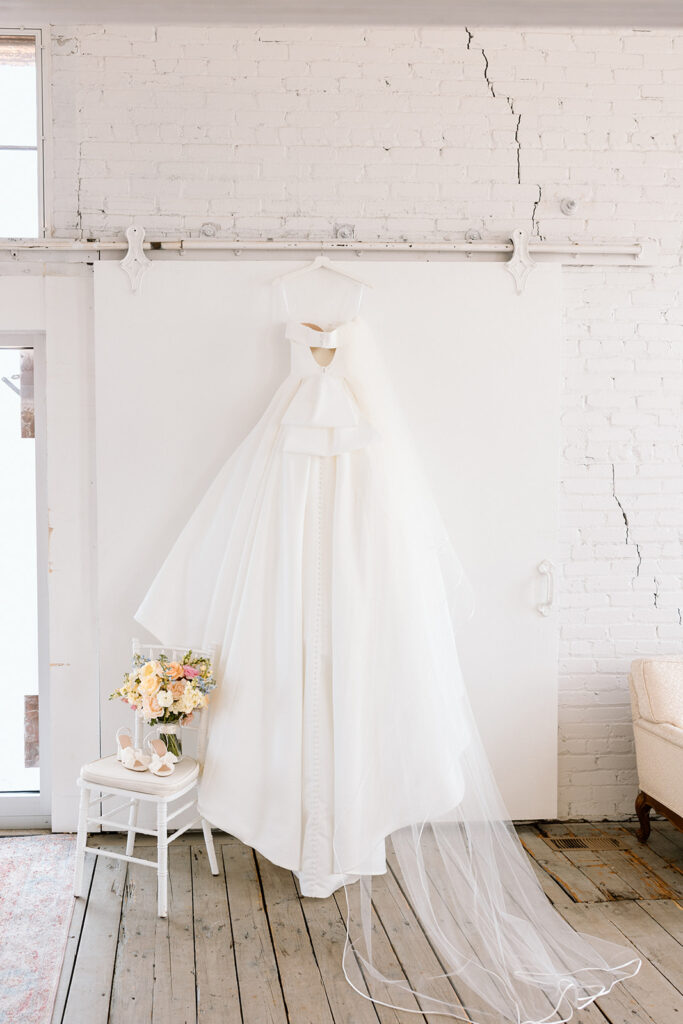 Bride posing in her wedding gown with natural light streaming through the window
